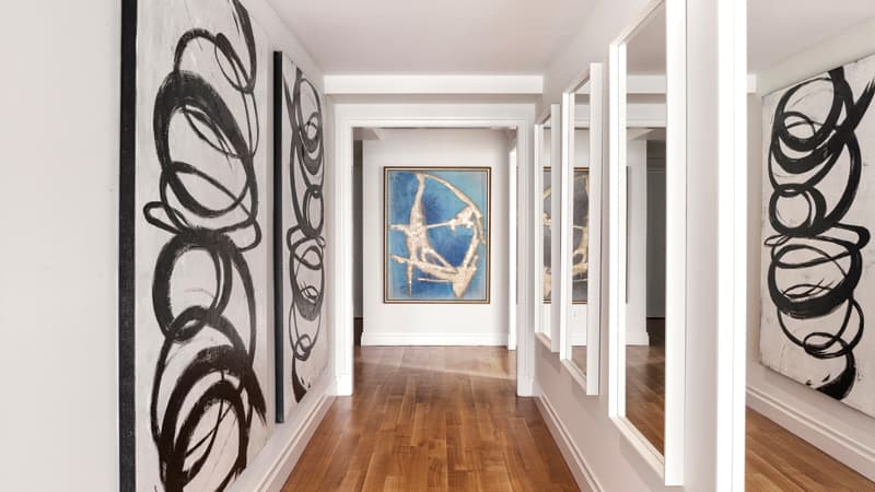 A series of mirrors placed across from artwork helps elongate a hallway. (Scott Morris/Design Recipes)
