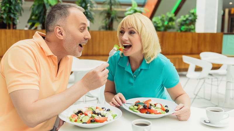 Joyful married couple eating healthy food