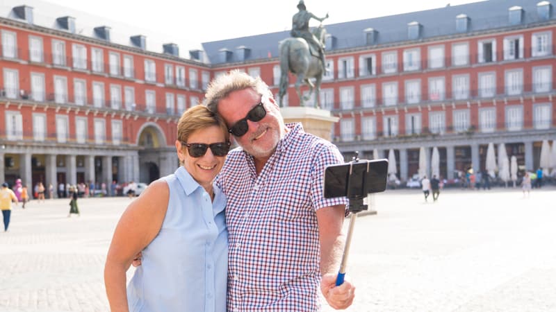 Happy retired senior tourist Couple Standing Taking Selfie in a European city