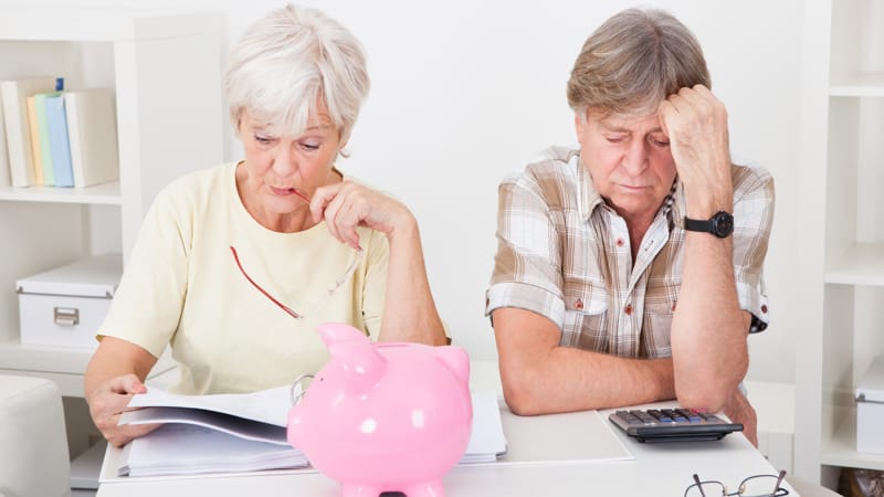 Portrait Of Upset Senior Couple Calculating Finance At Home