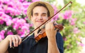 Happy man playing violin outside Image