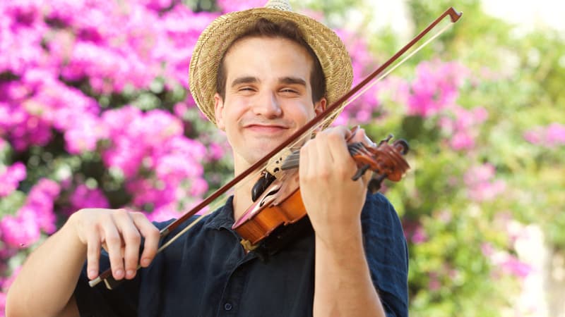 Happy man playing violin outside