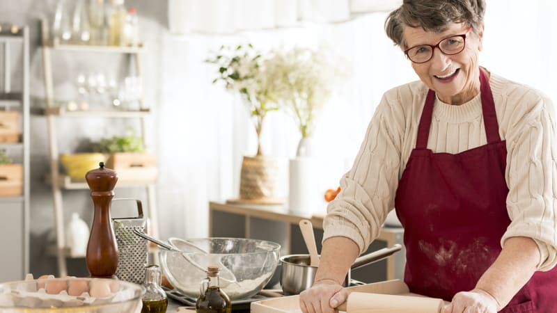 Senior woman cooking after following our tips for clearing up a holiday kitchen