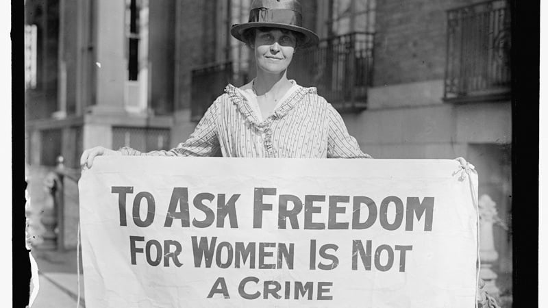 Suffragette holding a sign promoting women's right to vote