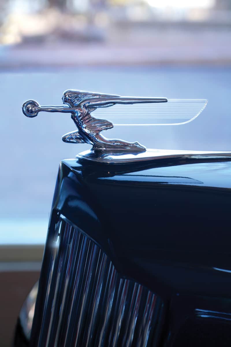 A sculptural '38 Packard Goddess of Speed radiator mascot atop a Packard One-Twenty Convertible Coupe