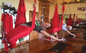 Two women perform aerial yoga at Fighting Gravity Fitness Image