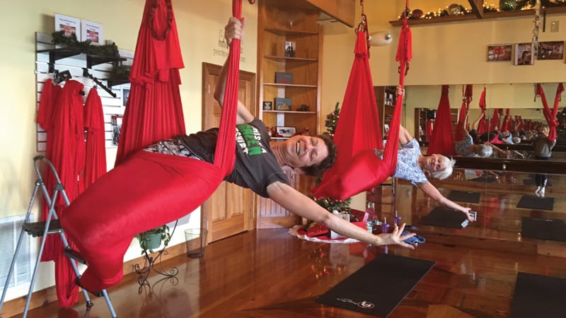 Two women perform aerial yoga at Fighting Gravity Fitness Image