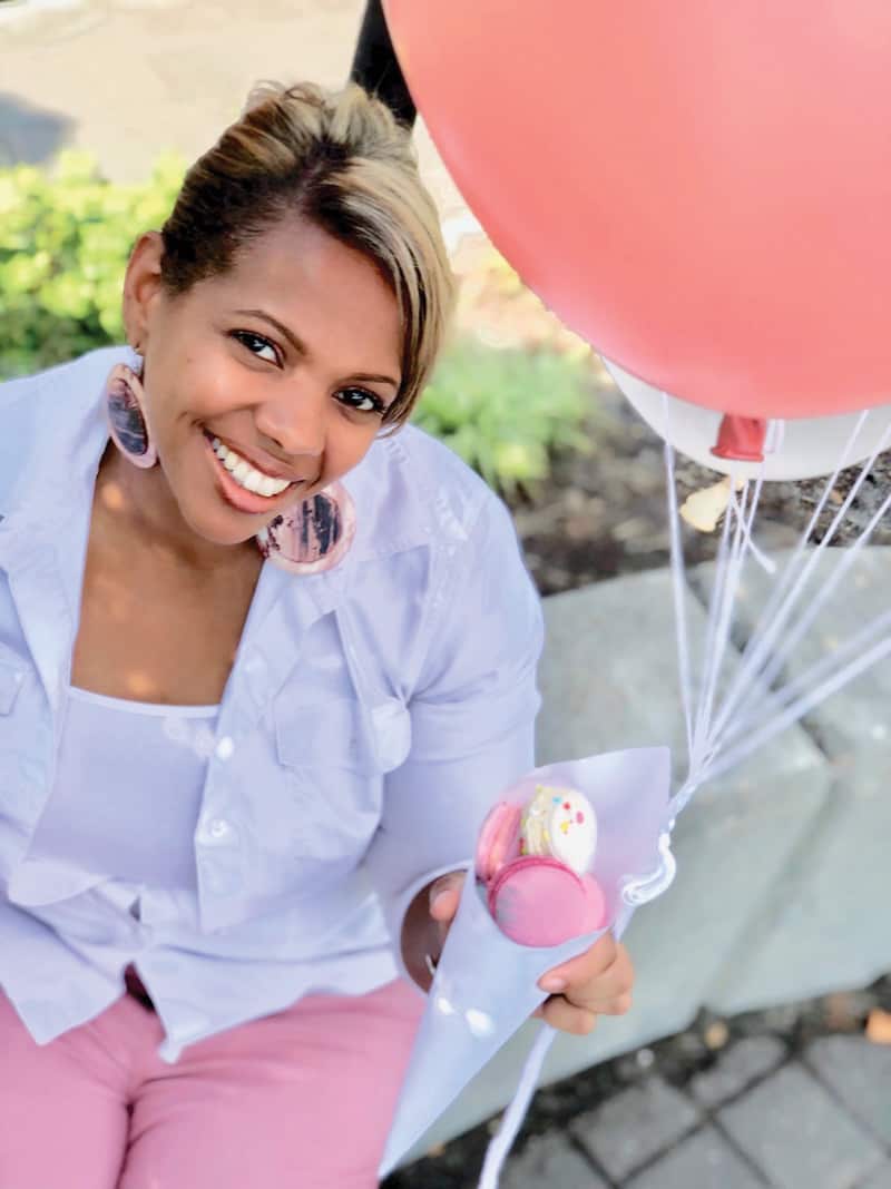 Kisha Frazier, owner of Hummingbirds Macarons & Desserts, holds a balloon