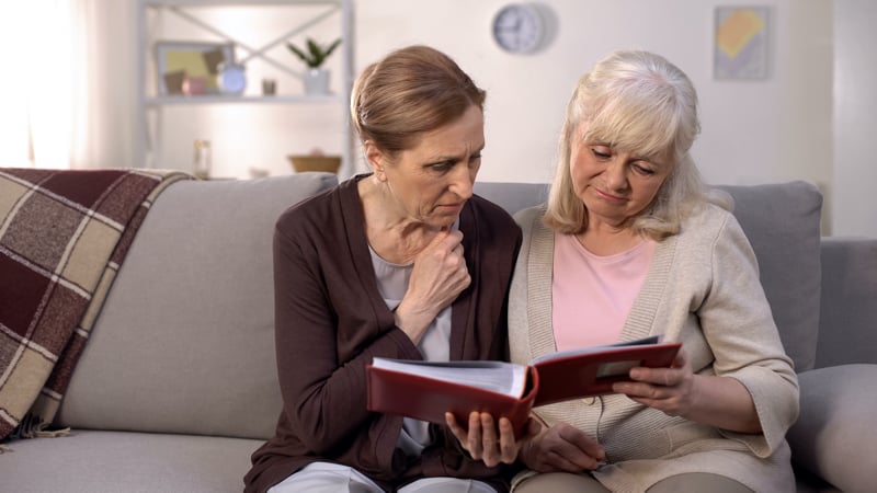 Two senior women look through a photo album