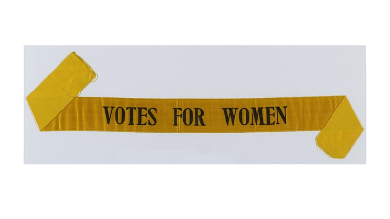Banner that says "votes for women" because they deserve them
