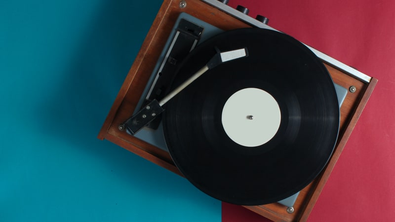 Retro vinyl record player on red-blue background. Top view