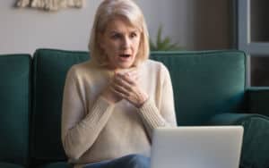Senior woman shocked at what she sees on her laptop Image