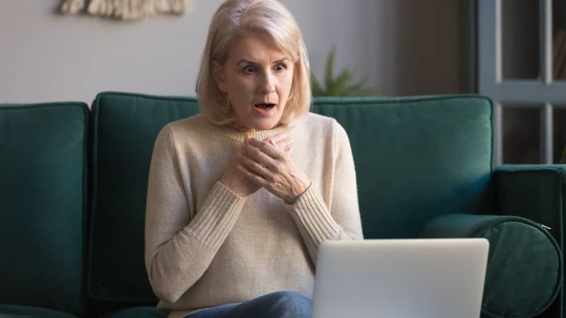 Senior woman shocked at what she sees on her laptop Image