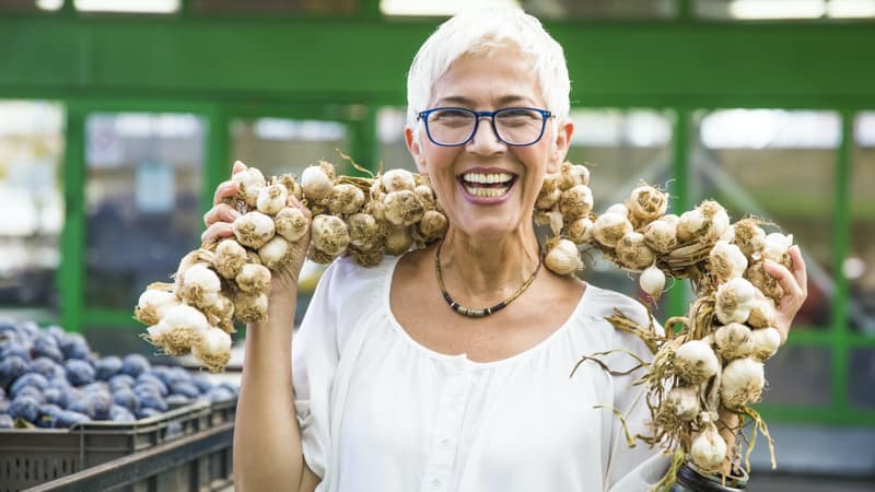 Senior woman keeping the flu and vampires away with superfoods like garlic