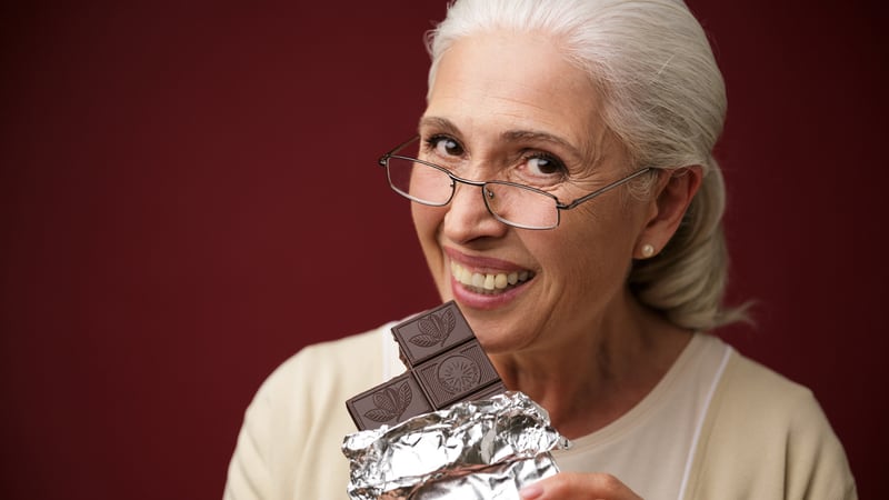 Senior woman loving herself some dark chocolate