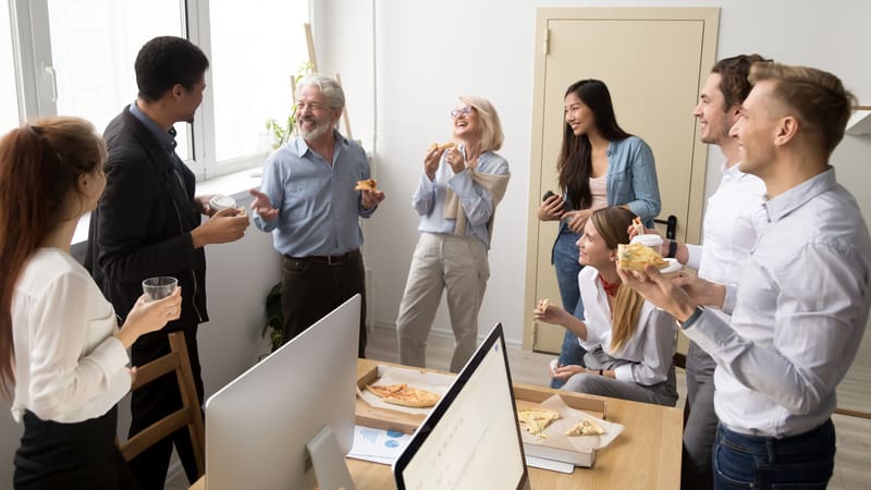 Coworkers eating lunch at work and laughing about it