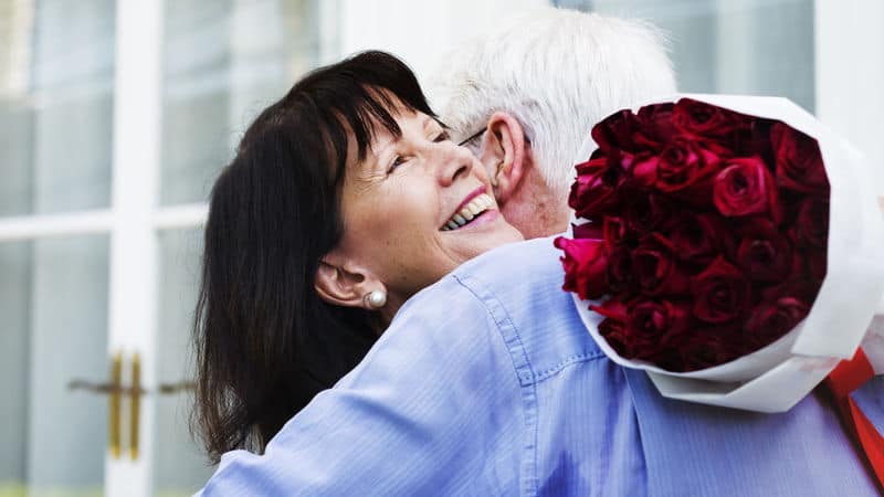 Woman hugging man holding roses while having boy problems Image