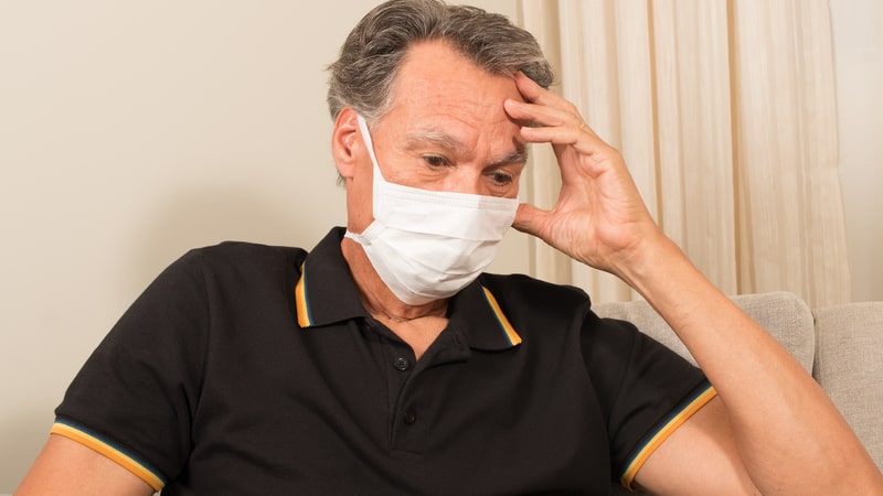 Man taking COVID-19 precautions with a face mask