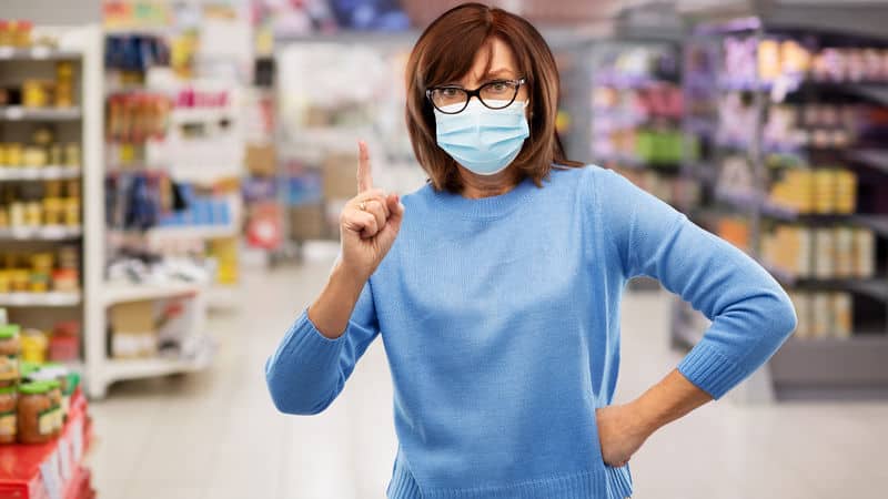 Woman practicing COVID-19 courtesy by wearing a mask to the grocery store Image