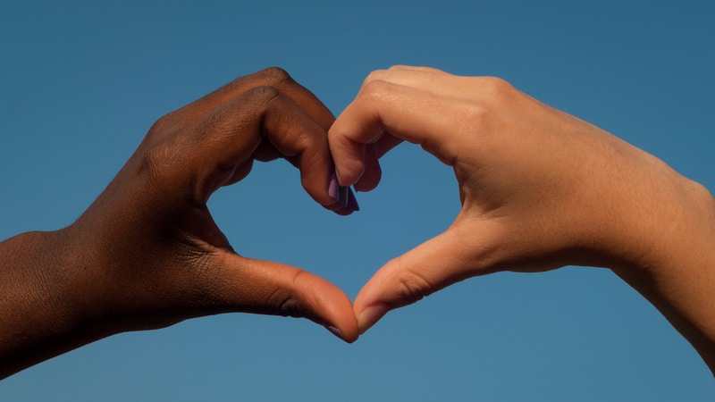 Two different hands creating a heart