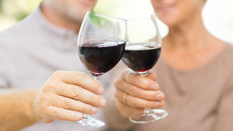 Two seniors drinking red wine because they are healthy