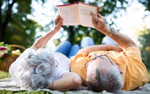 Seniors having a romantic picnic and reading Image