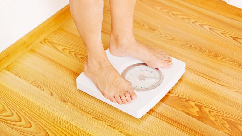 Senior on a scale to see if the diet worked Image