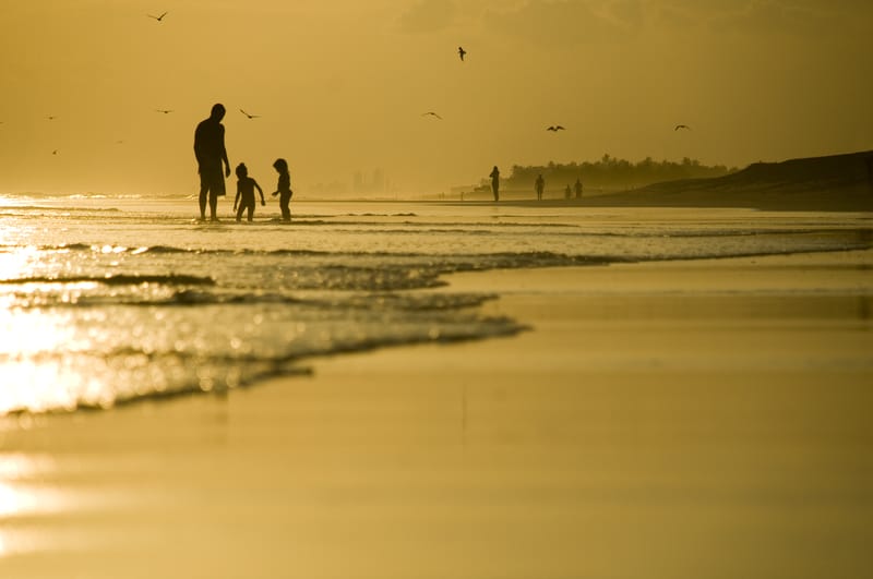 Dad with kids at seashore is part of childhood beach memories