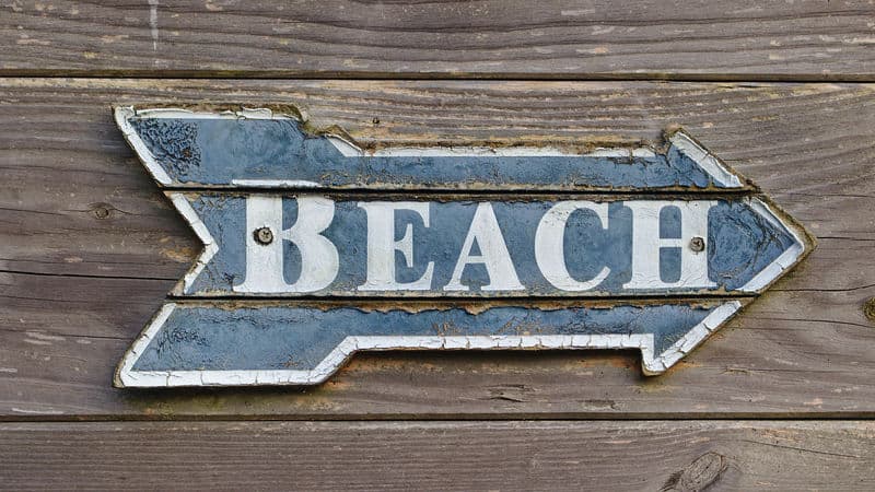 Sign pointing to the beach summons childhood beach memories Image