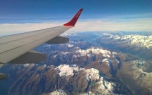 travel insurance benefits and warnings - view of mountain range from airplane Image