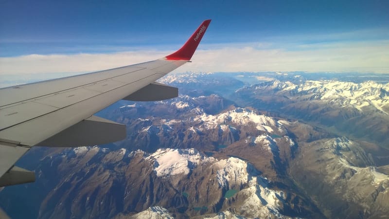 travel insurance benefits and warnings - view of mountain range from airplane
