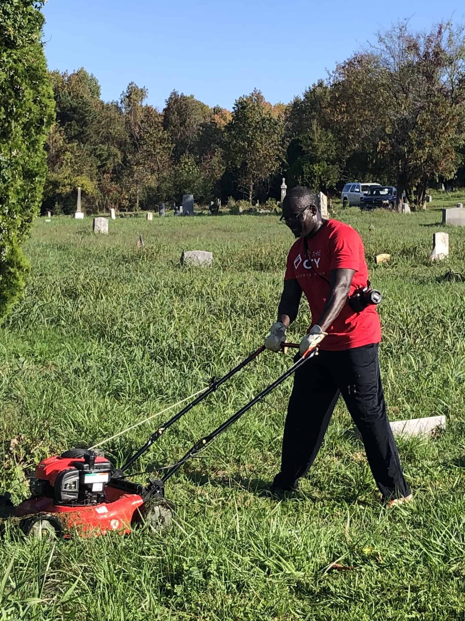 Volunteer mowing at Woodland Cemetery, a historic African American cemetery in Richmond, Virginia