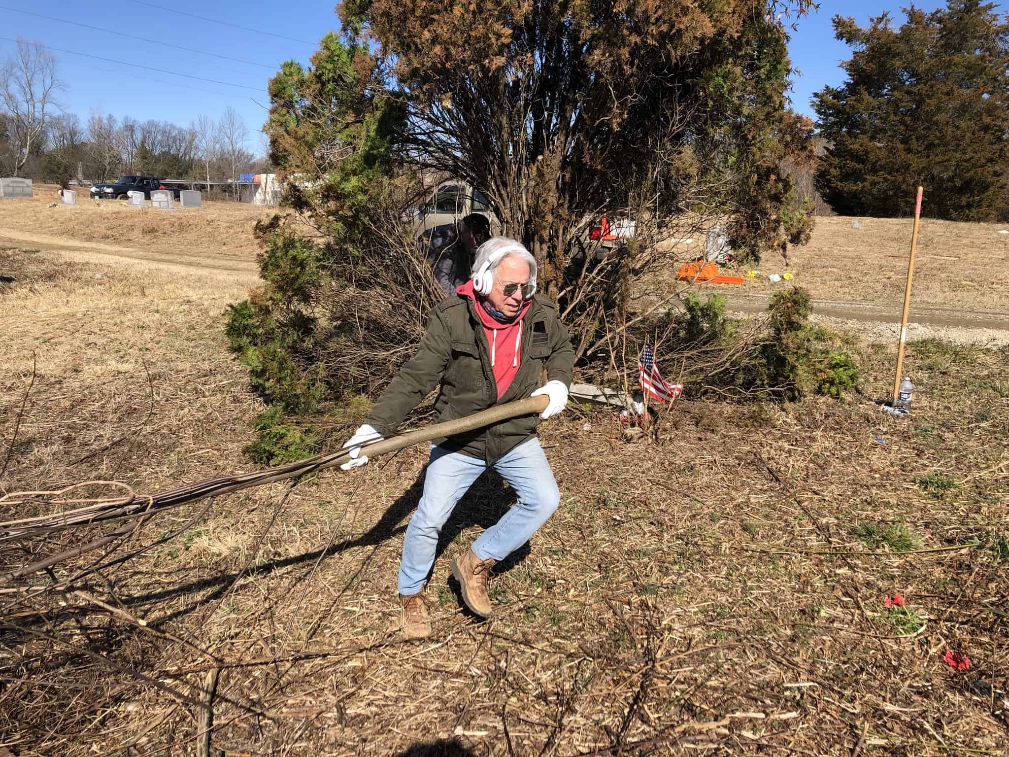 Volunteer clearing brush at Woodland Cemetery, a historic African American cemetery in Richmond, Virginia