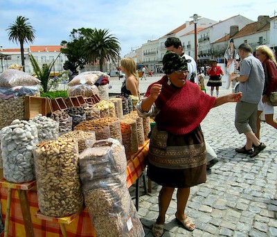 PHOTO: Portuguese tradeswoman selling dried fruits and nuts in the national dress, highlighting Nazare traditions and historic culture