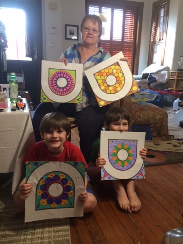 Grandmother and grandkids with several hand crafted kolams