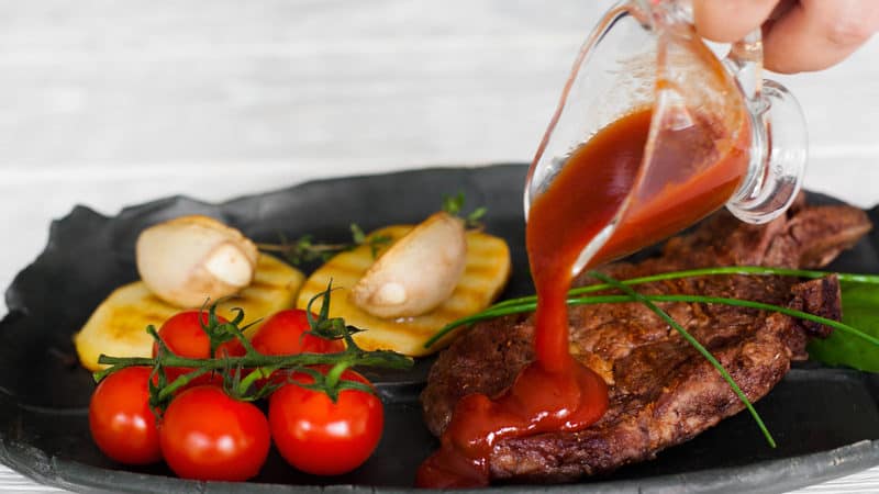 pouring ketchup on a steak. For the article on how to blame bad behavior on your state Image