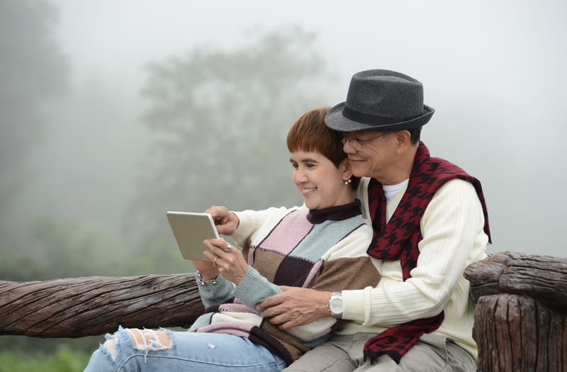 Baby boomer couple reading digital tablet