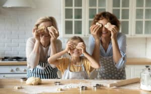 Multigenerational family at home, Grandmom, granddaughter, and mom in the kitchen making cookies. For “Moving Aging Parents into Your Home, Part 1.” Photo credit: Fizkes, Dreamstime Image