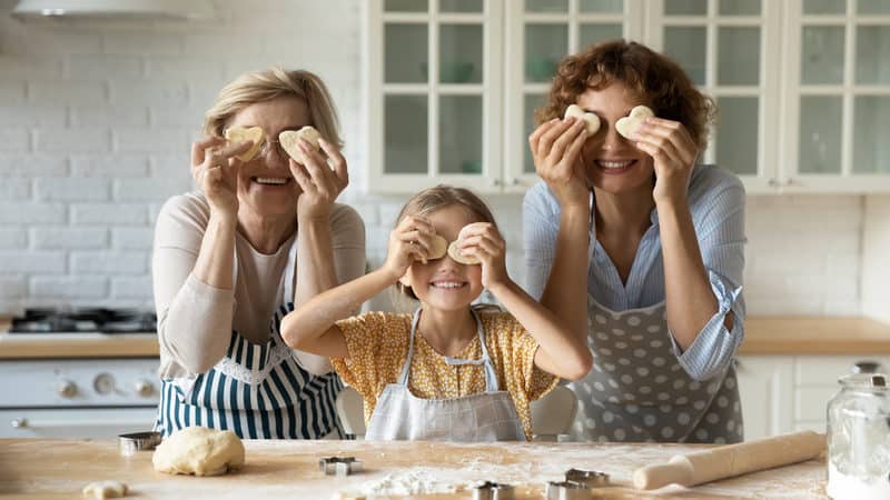 Multigenerational family at home, Grandmom, granddaughter, and mom in the kitchen making cookies. For “Moving Aging Parents into Your Home, Part 1.” Photo credit: Fizkes, Dreamstime Image