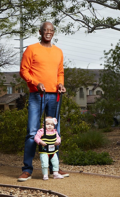 Jeffrey Nash demonstrates his invention, Juppy, as adults assist children who are learning to walk. Nash demonstrated the courage to start again with a fresh, new career