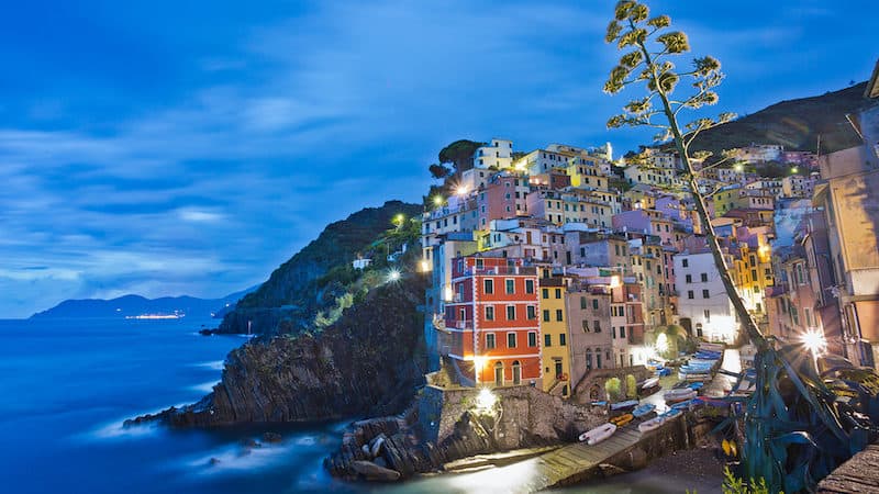 Riomaggiore, one of the Cinque Terre towns, is aglow at night. Credit, Rick Steves' Europefor Sciacchetrà wine and traditions Image