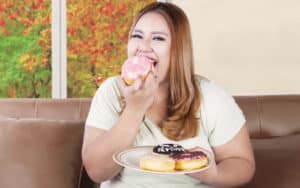 Obese daughter eating donuts Image