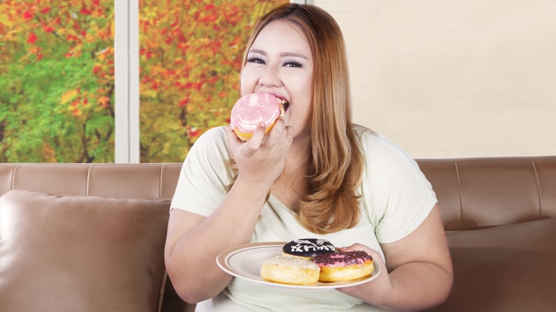 Obese daughter eating donuts