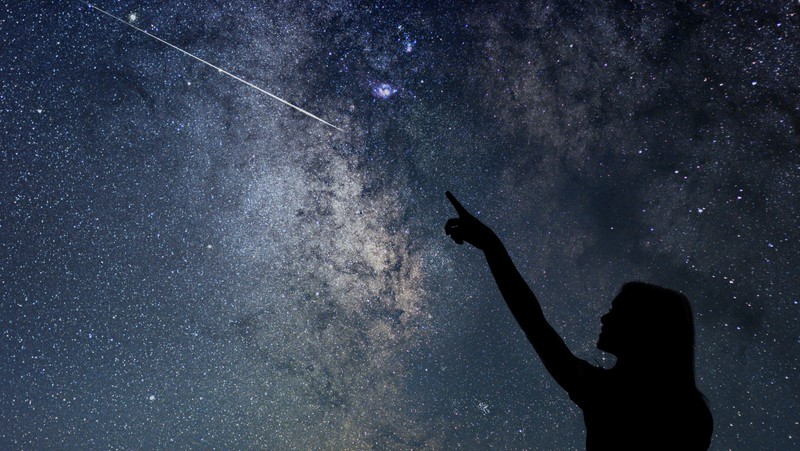 girl pointing at a meteor, for article on 2021 Perseid meteor shower