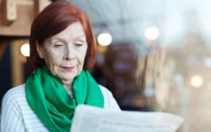 Senior woman reading political negativity Image