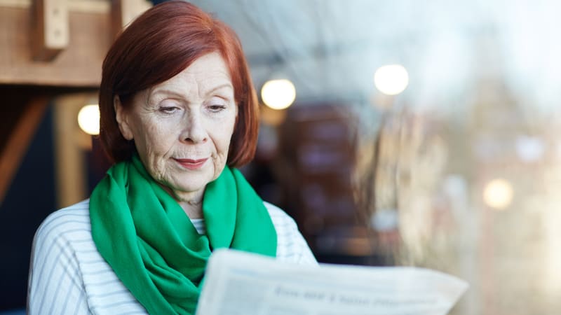 Senior woman reading political negativity
