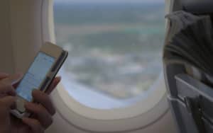Woman texting on airplane flight Image