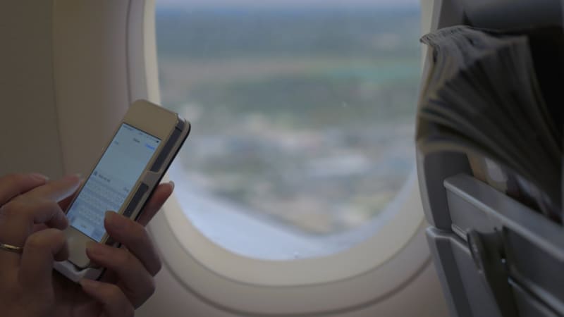 Woman texting on airplane flight