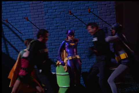 In Enter Batgirl, Exit Penquin, Batman and Robin have to pull apart the thugs who have ganged up on the heroine.