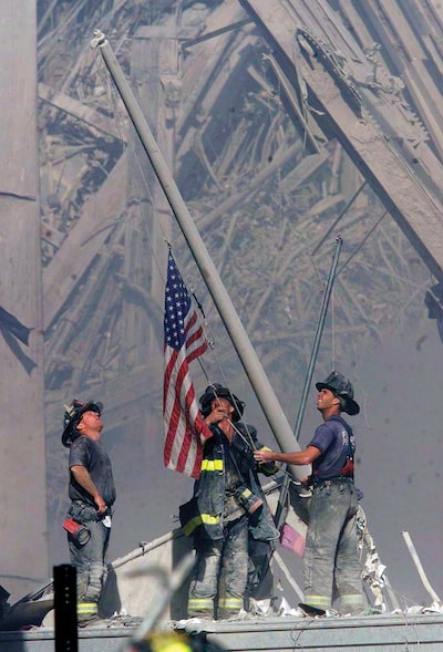 Sept. 11, 2001: Firefighters raise a U.S. flag at the site of the World Trade Center after two hijacked commercial airliners were flown into the buildings Sept. 11, 2001 in New York.